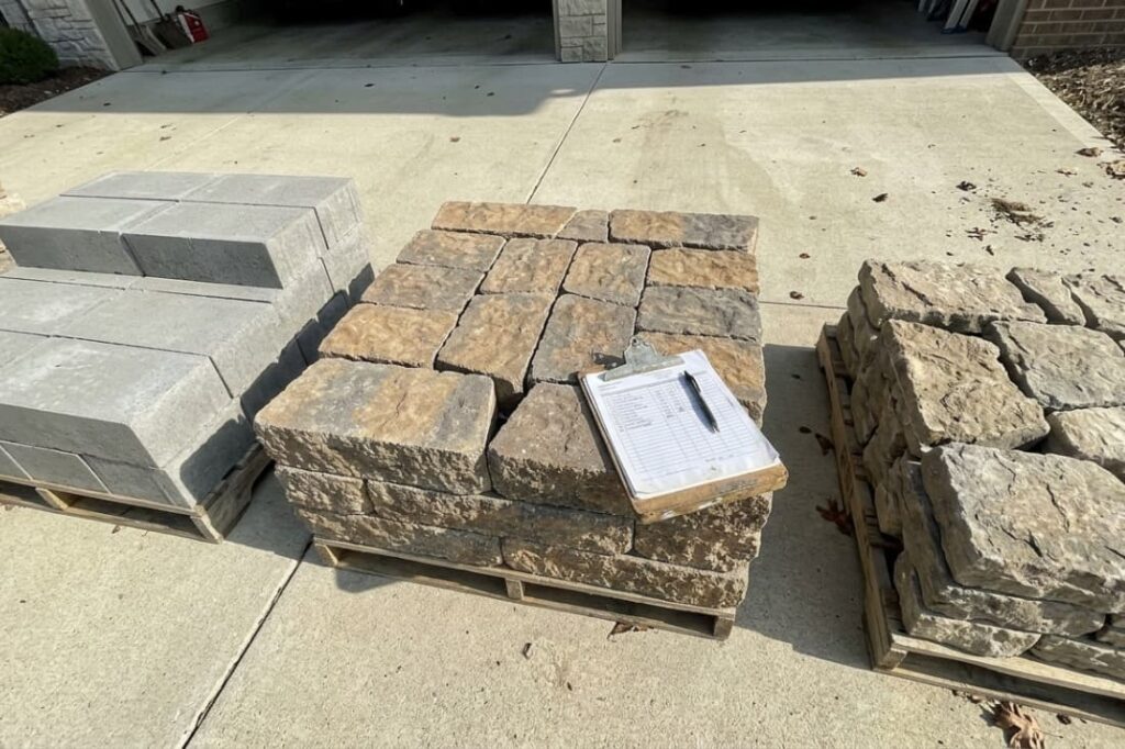 Pallets of stone blocks help homeowners estimate segmental retaining wall cost before installation begins. 